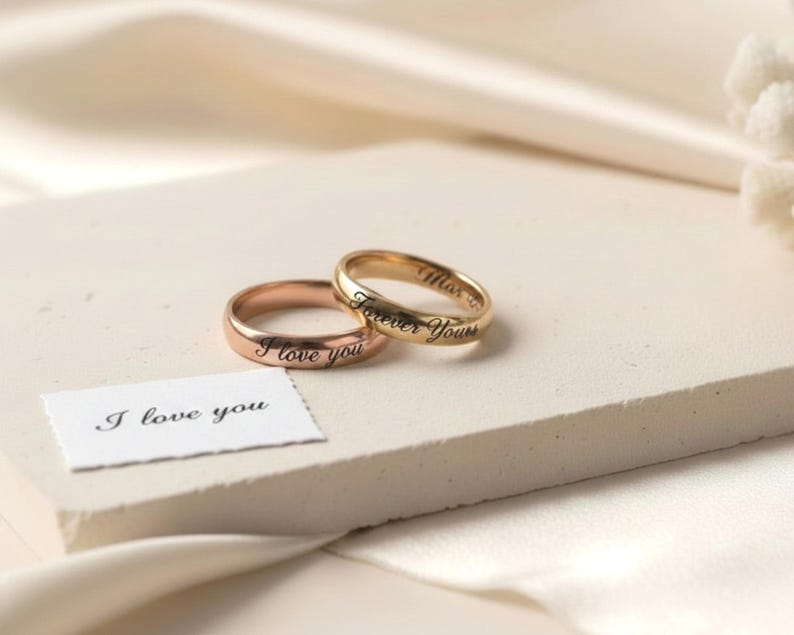 Peut inclure: Deux bagues en m&eacute;tal &agrave; la finition lisse, l'une dans un ton or rose et l'autre dans un ton or jaune. La bague en or rose est grav&eacute;e du texte I love you, et la bague en or jaune est grav&eacute;e du texte Forever Yours. Une petite carte blanche avec le texte I love you est incluse.