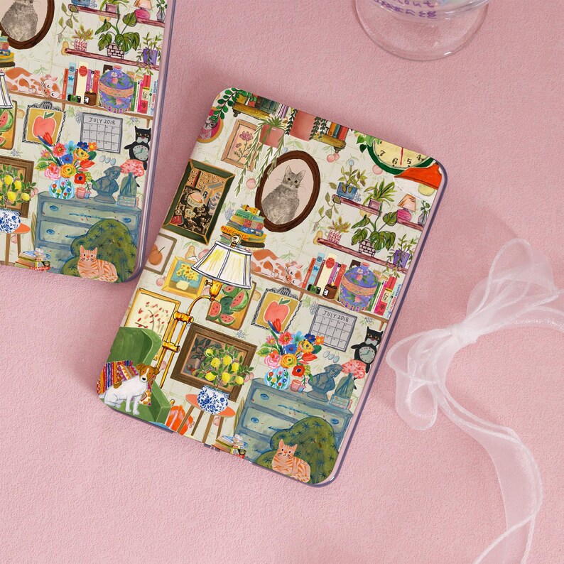 K&ouml;nnte beinhalten: Eine dekorative Handyh&uuml;lle mit einer skurrilen Illustration. Das Design umfasst ein Katzenportr&auml;t, gerahmte Kunstwerke, B&uuml;cherregale und Blumengestecke. Die Farbpalette ist sanft, mit Pastellt&ouml;nen und einem Hauch von Laune.