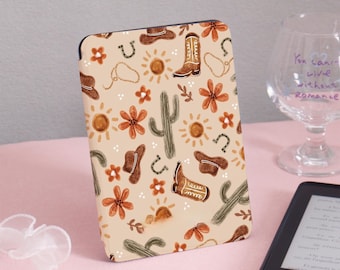 May include: A beige Kindle cover with a repeating pattern of brown cowboy boots, cacti, horseshoes, and suns.