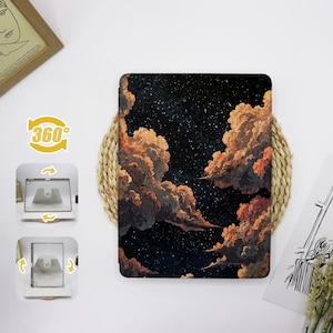 May include: A black and white galaxy-themed iPad case with a design of orange and brown clouds against a dark blue background with white stars. The case is made of a durable material and is designed to protect your iPad from scratches and bumps.