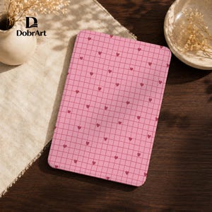 Op de afbeelding: Een rechthoekige e-reader hoes met een roze ruitpatroon bedekt met kleine donkerroze hartjes. De hoes heeft afgeronde hoeken en een glad oppervlak. De merknaam DobrArt is zichtbaar in de linkerbovenhoek van de afbeelding.