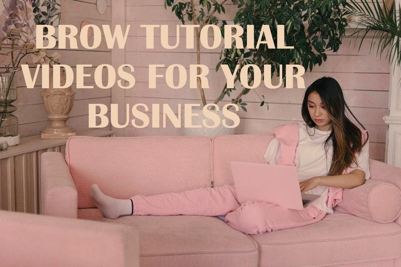 May include: A woman is sitting on a pink sofa with a laptop on her lap. She is wearing a white top and pink trousers. The text "BROW TUTORIAL VIDEOS FOR YOUR BUSINESS" is displayed on the wall behind her.