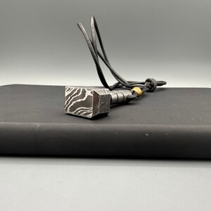 Damascus steel Thor’s Hammer (Mjölnir) necklace, ideal gift for him — husband, dad, brother, friend who loves Norse mythology or rugged artisan jewelry. Handcrafted in steel with strong norse symbolism, this hammer pendant is a meaningful birthday, anniversary or Father’s Day present that stands out for its unique material and design.