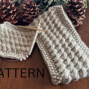 May include: Two beige knitted fabric swatches with a textured pattern. The word "PATTERN" is printed in black on a wooden surface.