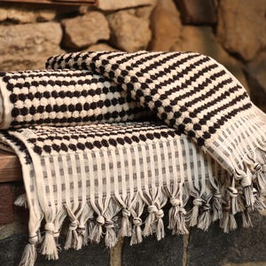 May include: Two black and white striped towels with fringe edges. The towels are made of a soft, absorbent material and are perfect for drying off after a shower or bath.