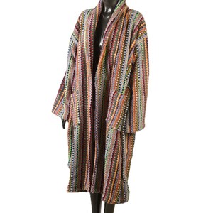 May include: A long, colorful striped robe with a shawl collar. The robe is made of a soft, textured fabric and has pockets on the sides.