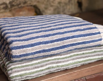 May include: Two striped towels stacked on top of each other. The top towel is blue and gray, and the bottom towel is green and gray.