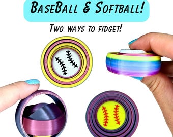 May include: Clicky Gyro Baseball & Softball! Two ways to fidget! Three circular fidget toys with concentric rings. One features a white baseball graphic, one a yellow softball graphic, and one a purple and magenta gradient finish.