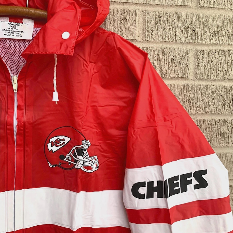 Puede incluir: Chaqueta de lluvia roja de los Kansas City Chiefs con una franja blanca y el logotipo del equipo en la parte delantera. La manga tiene una franja blanca con la palabra "CHIEFS" en negro.