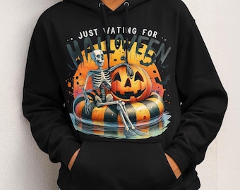 Peut inclure: Sweat à capuche noir avec un motif d'Halloween. Le design montre un squelette sur un flotteur en forme de citrouille, avec une lanterne et le texte "JUST WAITING FOR HALLOWEEN". L'arrière-plan comprend un coucher de soleil orange et des chauves-souris.