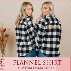 May include: Two women wearing black and white plaid flannel shirts with blue jeans. One shirt has the word "Bridesmaid" embroidered in gold on the back. The image also includes the text "FLANNEL SHIRT CUSTOM EMBROIDERY".