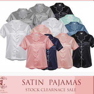 May include: A collection of satin pajamas in various colors, including white, gray, pink, navy, black, and blue. The short-sleeved shirts have a classic button-down design with a chest pocket. The image also includes the text "SATIN PAJAMAS" and "STOCK CLEARANCE SALE".