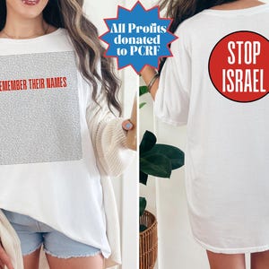 Puede incluir: Camiseta blanca con el texto "REMEMBER THEIR NAMES" en rojo en la parte delantera. La parte trasera de la camiseta presenta un círculo rojo con las palabras "STOP ISRAEL" en blanco. La camiseta también tiene un gráfico de estrella azul que dice "All Profits donated to PCRF".