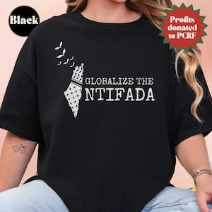 May include: Black crew neck t-shirt with a white graphic. The graphic features a stylized map outline with a black and white pattern, accompanied by the text "GLOBALIZE THE NTIFADA". A small green and red badge reads "Profits donated to PCRF".