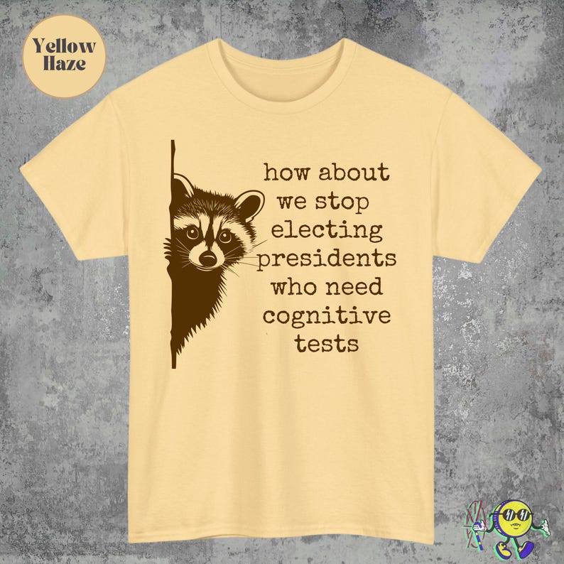 May include: A yellow haze t-shirt with a raccoon graphic peeking from the left side. The text reads, "how about we stop electing presidents who need cognitive tests."