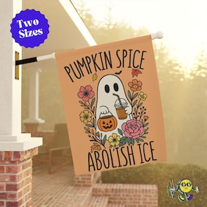 May include: A rectangular orange flag with the words "PUMPKIN SPICE ABOLISH ICE" and a cartoon ghost holding a pumpkin and a drink. The flag is decorated with flowers and autumn leaves. The flag is hanging outside.