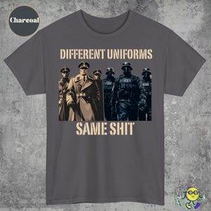 Könnte beinhalten: Anthrazitfarbenes T-Shirt mit dem Text "DIFFERENT UNIFORMS SAME SHIT" in einer verwitterten Schriftart. Die Grafik zeigt eine Gruppe von Personen in verschiedenen Uniformen.