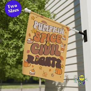 May include: A rectangular garden flag with a tan background featuring the text PUMPKIN SPICE & CIVIL RIGHTS in large, bold, retro-style lettering. The design includes small illustrations of pumpkins, autumn leaves, pies, and stars.