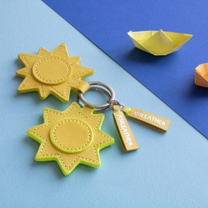 Personalisierter Sonnen-Schlüsselanhänger aus Saffiano-Leder. Ausgezeichnete Geschenkidee zum Glück. 100 % handgefertigt in Italien.