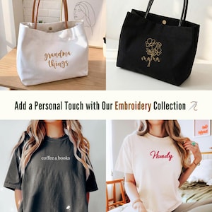 May include: A collection of embroidered items, including a white tote bag with "grandma things" and a black tote bag with a floral design and "mama". Also shown are two t-shirts, one gray with "coffee & books" and one cream with "Howdy".