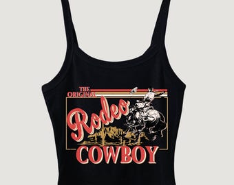 May include: Black tank top with a graphic print of a cowboy riding a horse. The graphic includes the text "The Original Rodeo Cowboy".