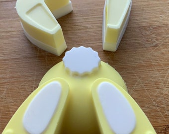 May include: A yellow and white bunny shaped soap mold with three pieces. The mold is made of silicone and has a smooth finish.