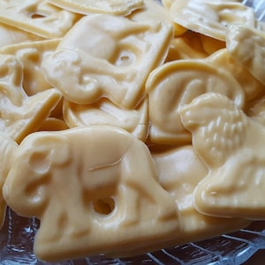 Könnte beinhalten: Nahaufnahme einer Schüssel voller weißer Schokoladen-Tierfiguren. Die Süßigkeiten sind in einem zufälligen Muster angeordnet und alle gleich groß und geformt. Die Süßigkeiten sind aus weißer Schokolade und haben eine glatte, glänzende Oberfläche.