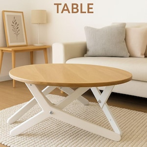 May include: A two-in-one coffee dining table with a light wood top and white folding legs. The round tabletop is made of light-coloured wood. The legs are white and cross in an X shape. The text "Two-in-One COFFEE DINING TABLE" is at the top.