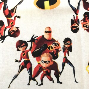May include: A white fabric with a repeating pattern of the Incredibles family. The family is in their superhero costumes, with Mr. Incredible, Elastigirl, Violet, Dash, and Jack-Jack. The pattern also includes the iconic "I" symbol from the movie.