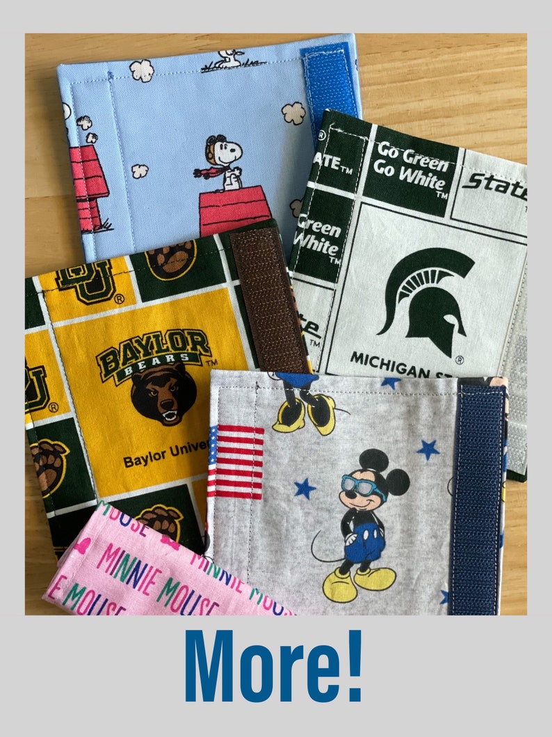 May include: Five different fabric swatches with various designs. The swatches are folded and stacked on top of each other. The top swatch is light blue with a white cloud pattern and a cartoon Snoopy. The second swatch is white with a green and white checkered pattern and the text "Go Green Go White". The third swatch is yellow with a green and yellow checkered pattern and the text "Baylor Bears". The fourth swatch is gray with a white star pattern and a cartoon Mickey Mouse wearing sunglasses. The fifth swatch is pink with a white heart pattern and the text "Minnie Mouse".