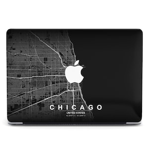 May include: A black laptop with a map of Chicago in grayscale on the left side and a solid black area on the right. The Apple logo is in white. The word "CHICAGO" and the coordinates are printed in white.