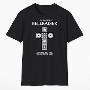 May include: Black t-shirt with a white graphic of a cross made of puzzle pieces. The text "Clive Barker's Hellraiser" is above the cross and "Pleasure and pain are one in the same." is below the cross.