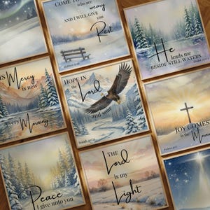 May include: A collection of square art prints with winter landscape scenes and inspirational quotes. Each print features a different design, including an eagle, a cross, and snowy forests. The prints are framed in light brown wood.