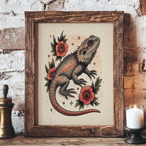 May include: A framed print featuring a stylized illustration of a bearded dragon lizard with red and gray tones, surrounded by red flowers and green leaves. The artwork is set against a light background and framed in a rustic wooden frame.