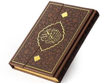 May include: A brown leather-bound book with gold accents and ornate floral patterns. The cover features gold Arabic calligraphy within a decorative frame. The book is closed, with a magnetic clasp.