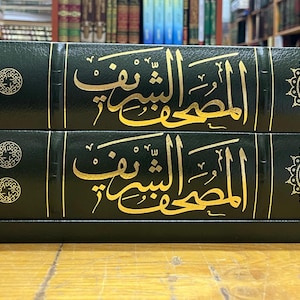 May include: Two green leather-bound books with gold lettering and decorative designs. The title of the books is "al-muqaddimah" in Arabic.