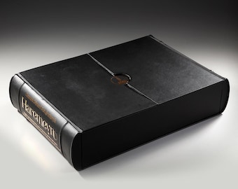 May include: A black leather-bound box with gold lettering that reads "Haremey" on the spine. The box has a circular cutout on the top.