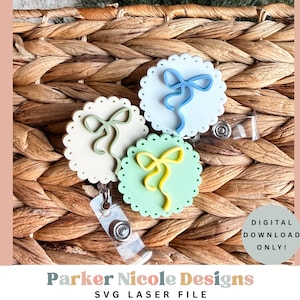 May include: Three badge reels with scalloped edges and bow designs in light green, blue, and yellow. The reels are on a woven basket background. Text on the image reads "DIGITAL DOWNLOAD ONLY!" and "Parker Nicole Designs SVG LASER FILE."
