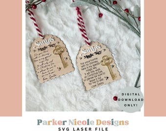 May include: Two wooden Christmas ornaments with the text "Santa's Magic Key" and a key illustration. Each ornament has a red and white twine for hanging. The ornaments are on a white, fluffy surface with sprigs of greenery and red berries.