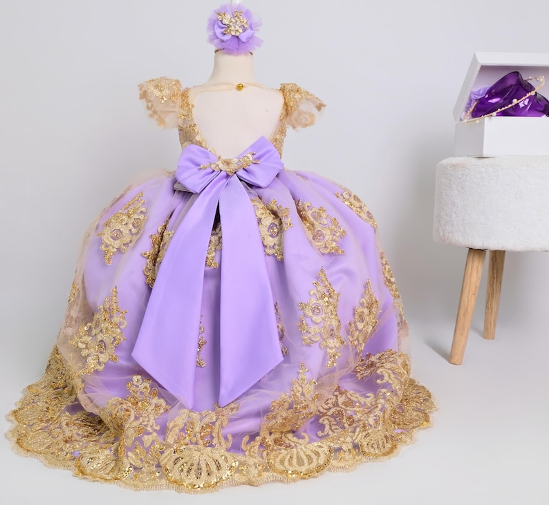 a purple and gold dress with a purple bow