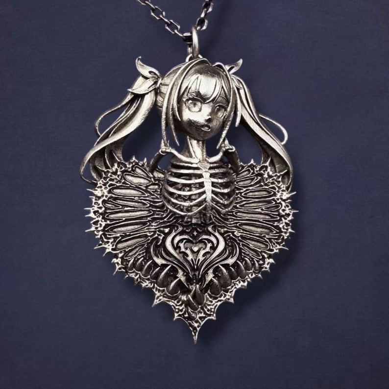 May include: A silver pendant necklace featuring a stylized girl with pigtails and a skeletal torso. The pendant is heart-shaped with intricate detailing and a spiky border, suspended from a delicate chain.