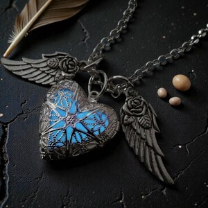 Pu&ograve; includere: Una collana con pendente a forma di cuore argentato con un centro blu brillante, ali e accenti di rose. La collana &egrave; su una catena ed &egrave; accompagnata da una piuma e piccole perle rotonde. Il ciondolo ha un design intricato e traforato.