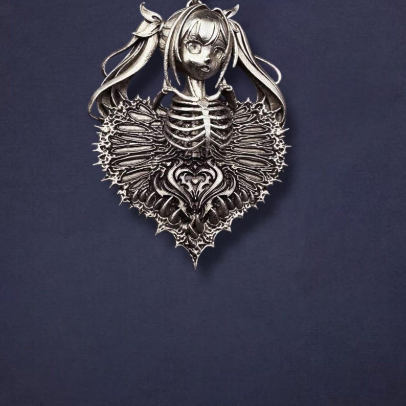 May include: A silver-colored pendant featuring a stylized anime-style girl with long hair and a skeletal torso. The pendant is heart-shaped with intricate, spiky detailing around the edges. The background is a solid, dark blue.