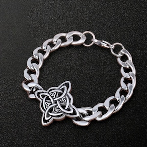 Peut inclure: Un bracelet en argent avec un charme en forme de nœud celtique. Le bracelet est de style chaîne curb et se ferme avec un fermoir à homard.