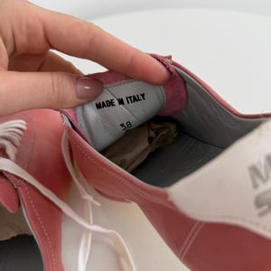 May include: Pink leather sneakers with white laces and a white and gray sole. The interior shows "MADE IN ITALY" and size 38. The brand name "SIXTY" is visible on the side.