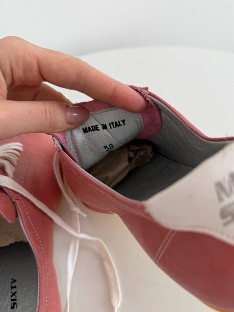 May include: Pink leather sneakers with white laces and a white and gray sole. The interior shows "MADE IN ITALY" and size 38. The brand name "SIXTY" is visible on the side.