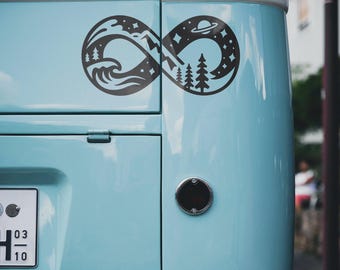May include: A black infinity symbol sticker with a nature theme is affixed to a light blue vehicle. The design includes mountains, trees, waves, stars, and a planet. The vehicle's license plate and a round black object are also visible.
