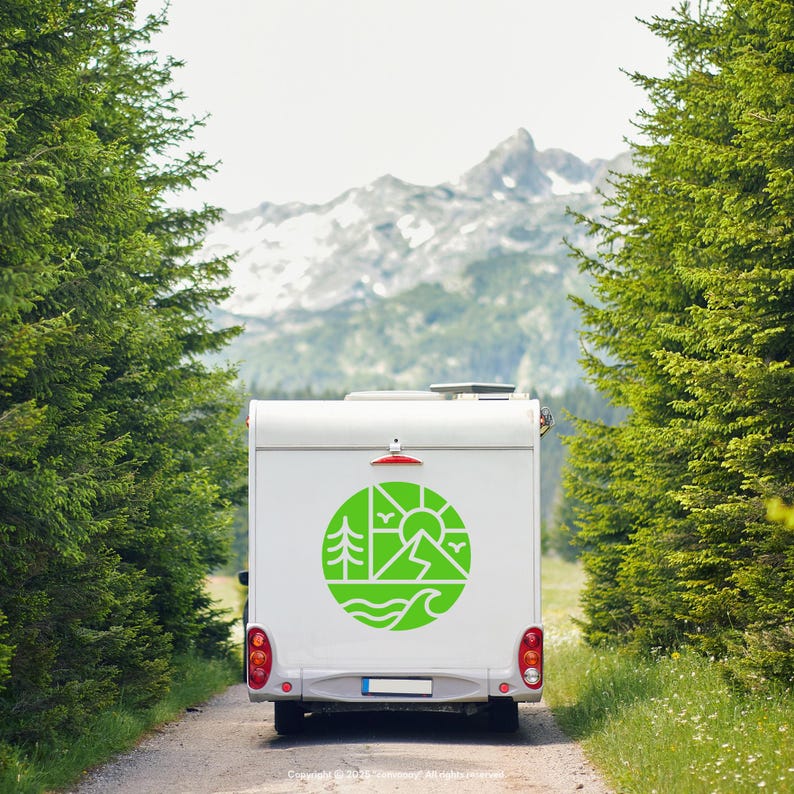 May include: A white camper van with a green circular graphic of a mountain, sun, trees, birds, and waves. The van is on a dirt road lined with tall green trees, with a mountain in the background.