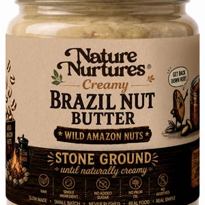 May include: A glass jar of Nature Nurtures Creamy Brazil Nut Butter with a white lid. The tan label features the text Nature Nurtures, Creamy Brazil Nut Butter, Wild Amazon Nuts, and Stone Ground until naturally creamy, with icons for raw, single ingredient, no added sugar, no palm oil, and no additives.