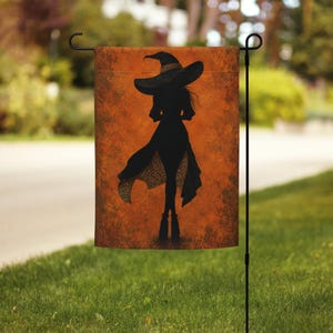 Könnte beinhalten: Eine rechteckige Gartenflagge mit der schwarzen Silhouette einer Figur, die einen breitkrempigen Hut und ein Kleid mit Leopardenmuster auf der Unterseite trägt. Der Hintergrund ist in einer strukturierten, fleckigen orangefarbenen Tönung mit dunkelbraunen Akzenten gehalten.